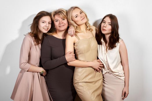 Happy Family of Mother with Three Daughters on Light Grey Background. Fashion Style Studio Portrait. Beautiful Women wearring Femininity Beige Dresses. Mothers Day, Womens Day or March 8 Style