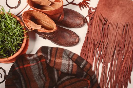 Fashion flat lay with autumnal clothing - scarf, boots, bag, bright wooden accessories. Beautiful cozy trend collection for autumn season