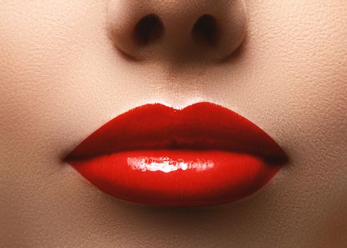 Closeup shot of beautiful full lips with red glossy make-up. Perfect bright lipstick. Plastic surgery or makeup concept. Clean skin and plump lips