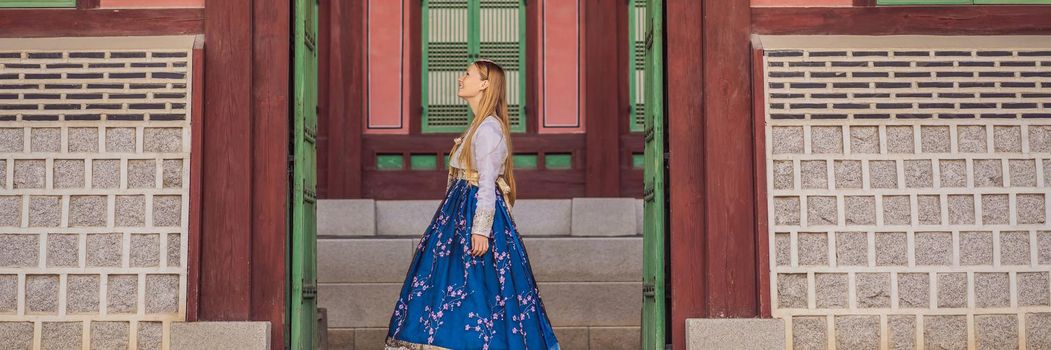 Young caucasian female tourist in hanbok national korean dress. Travel to Korea concept. National Korean clothing. Entertainment for tourists - trying on national Korean clothing. BANNER, LONG FORMAT