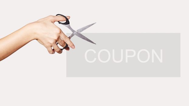 Female Hand is Holding Scissors. Copy Space for your Text. Isolated on White Background. Light Grey Coupon for Shopping Sales