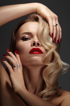 Beautiful Sexy Woman with Fashion Make-up and Blond Curly Wave Hairstyle, Bright Accessories. Glamour Pin-up Girl with Red lips. American Diva Style with Brilliant Earrings and Rings