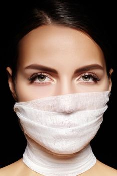 Beautiful woman with a bandage mask on face. Fashion eye make-up. Beauty plastic surgery or protection hygiene in viral covid-19 pandemic