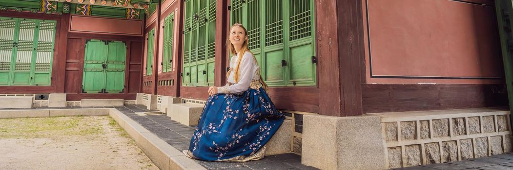 Young caucasian female tourist in hanbok national korean dress. Travel to Korea concept. National Korean clothing. Entertainment for tourists - trying on national Korean clothing. BANNER, LONG FORMAT