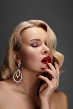 Beautiful Sexy Woman with Fashion Make-up and Blond Curly Wave Hairstyle, Bright Accessories. Glamour Pin-up Girl with Red lips. American Diva Style with Brilliant Earrings and Rings