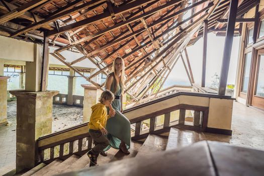 mother and son tourists in abandoned and mysterious hotel in Bedugul. Indonesia, Bali Island. Bali Travel Concept.