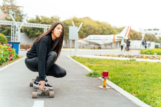 Young girl on longboard smiling. Outdoors, lifestyle