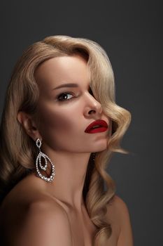 Beautiful Sexy Woman with Fashion Make-up and Blond Curly Wave Hairstyle, Bright Accessories. Glamour Pin-up Girl with Red lips. American Diva Style with Brilliant Earrings and Rings