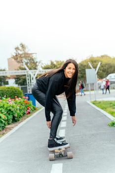 Young girl on longboard smiling. Outdoors, lifestyle