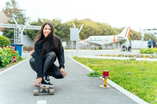 Young girl on longboard smiling. Outdoors, lifestyle