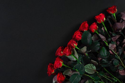 Bouquet of red roses on a black background. Top view. Flat lay. Copy space. Still life Valentine's Day