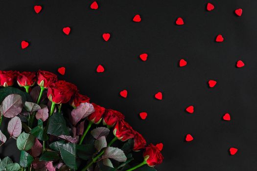 Bouquet of red roses on a black background. Top view. Flat lay. Copy space. Still life. Valentines day greeting card.