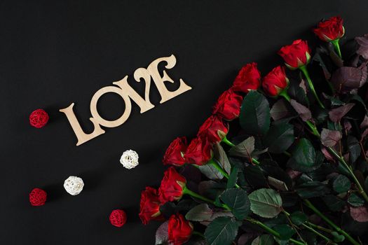 Bouquet of red roses on a black background. Top view. Flat lay. Copy space. Still life