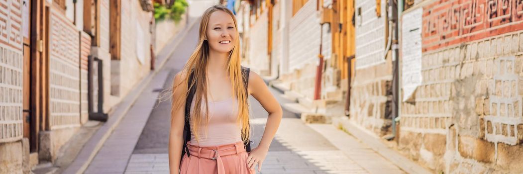 Young woman tourist in Bukchon Hanok Village is one of the famous place for Korean traditional houses have been preserved. Travel to Korea Concept. BANNER, LONG FORMAT