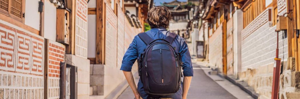 Young man tourist in Bukchon Hanok Village is one of the famous place for Korean traditional houses have been preserved. Travel to Korea Concept. BANNER, LONG FORMAT