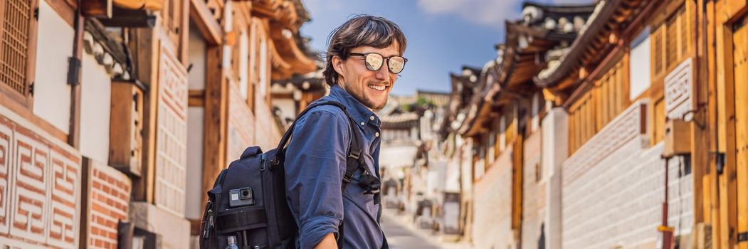 Young man tourist in Bukchon Hanok Village is one of the famous place for Korean traditional houses have been preserved. Travel to Korea Concept. BANNER, LONG FORMAT