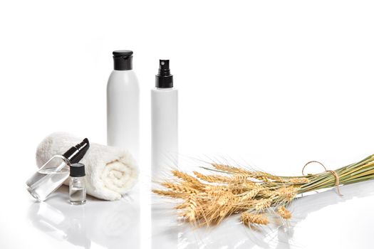 Herbal and mineral skincare. Jar of cream, oil with wheat, white cosmetic bottles. Without label. The concept for advertising cosmetics. Still life. Copy space