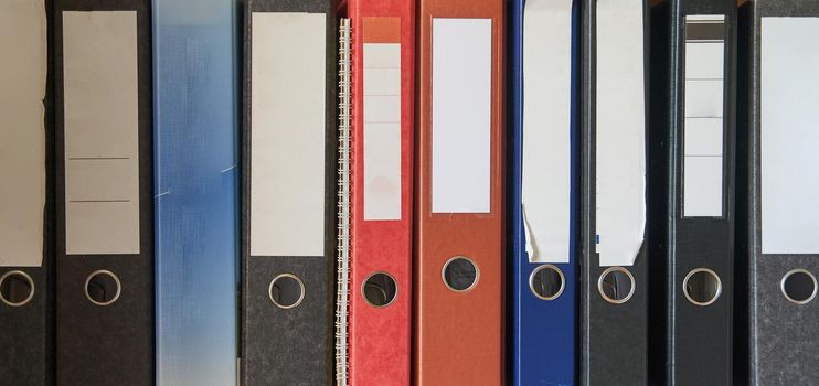 Colored folders for office files and paper on a shelf. Background image. High-quality photo