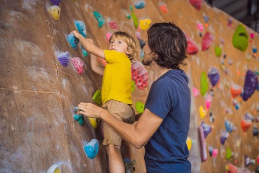 Dad and son at the climbing wall. Family sport, healthy lifestyle, happy family.