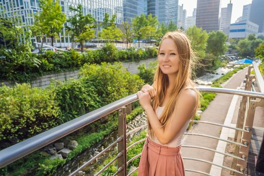 Young woman tourist in Cheonggyecheon stream in Seoul, Korea. Cheonggyecheon stream is the result of a massive urban renewal project. Travel to Korea Concept.