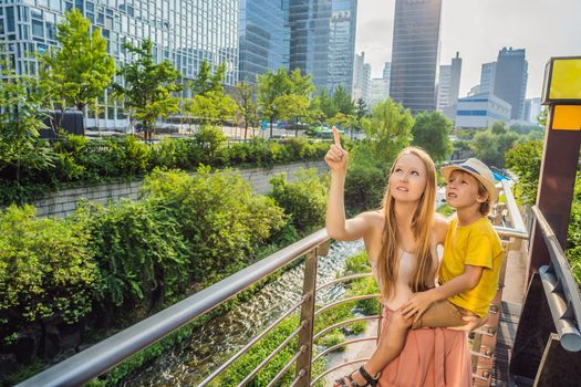 Mom and son tourists in Cheonggyecheon stream in Seoul, Korea. Cheonggyecheon stream is the result of a massive urban renewal project. Travel to Korea Concept.