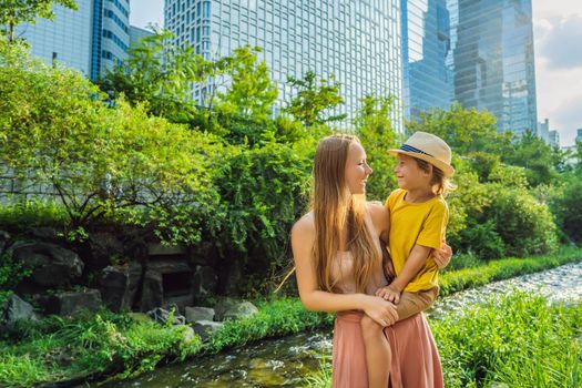 Mom and son tourists in Cheonggyecheon stream in Seoul, Korea. Cheonggyecheon stream is the result of a massive urban renewal project. Travel to Korea Concept.