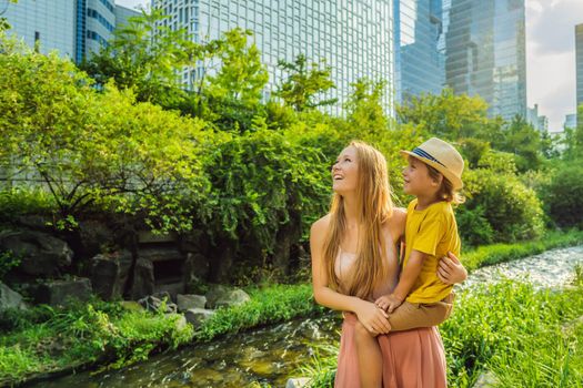 Mom and son tourists in Cheonggyecheon stream in Seoul, Korea. Cheonggyecheon stream is the result of a massive urban renewal project. Travel to Korea Concept.