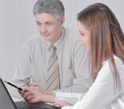 two members of the company sitting behind a Desk in the office