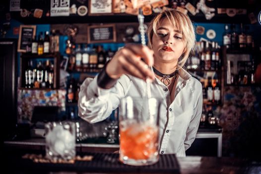 Girl bartender creates a cocktail on the beerhouse