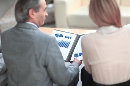 rear view .business couple discussing a financial chart.