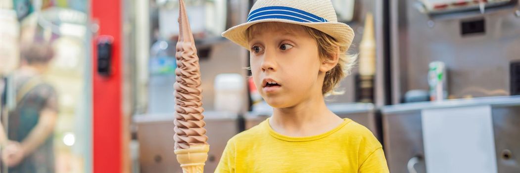 Little tourist boy eating 32 cm ice cream. 1 foot long ice cream. Long ice cream is a popular tourist attraction in Korea. Travel to Korea concept. Traveling with children concept. BANNER, LONG FORMAT