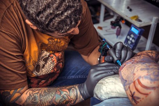 Professional tattoo artist posing in tattoo studio./Master at work in tattoo parlour.