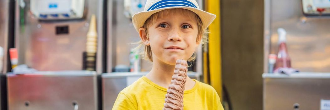 Little tourist boy eating 32 cm ice cream. 1 foot long ice cream. Long ice cream is a popular tourist attraction in Korea. Travel to Korea concept. Traveling with children concept. BANNER, LONG FORMAT