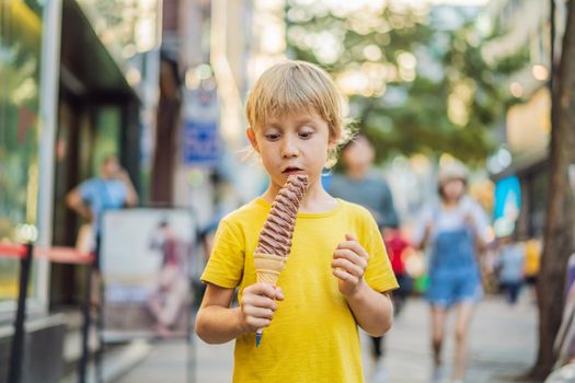 Little tourist boy eating 32 cm ice cream. 1 foot long ice cream. Long ice cream is a popular tourist attraction in Korea. Travel to Korea concept. Traveling with children concept.