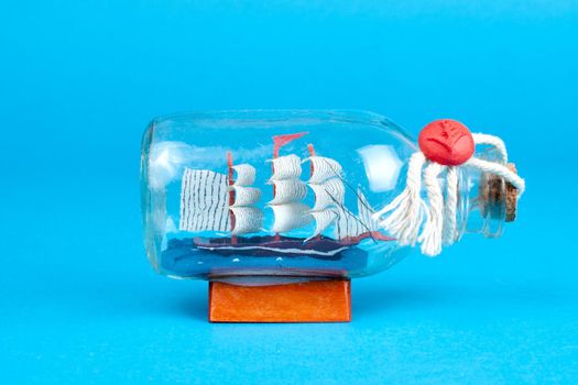 Ship in a bottle isolated on blue