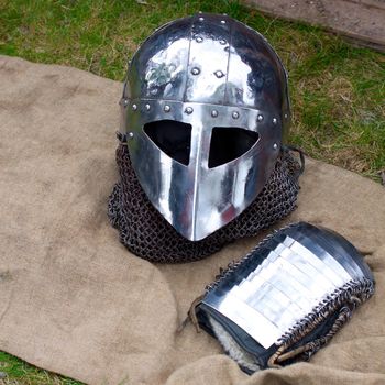 Knight`s helmet and mitten lying on a canvas