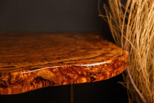 The edge of wooden stylish table made of solid walnut with epoxy resin in stylish interior