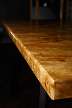 Table top for a table made of poplar burl wood and transparent epoxy resin. The resin is varnished and polished, the wood is saturated with tung oil.