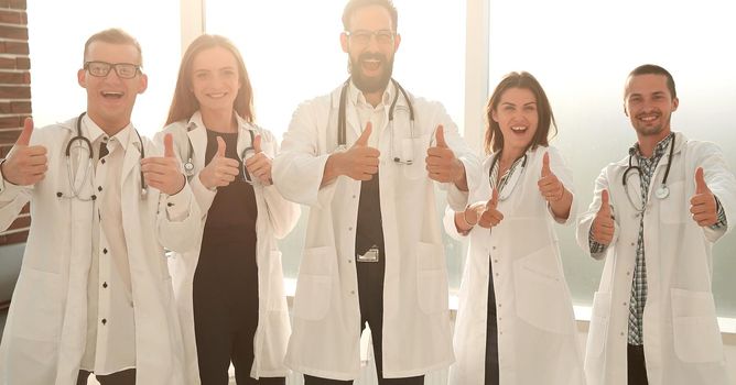 healthcare and medical - professional young team or group of doctors showing thumbs up