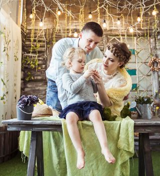 five year old girl and loving parents are considering a gift in the living room on the table