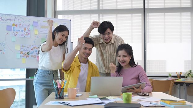 Startup business team celebrating business success or victory together in office.