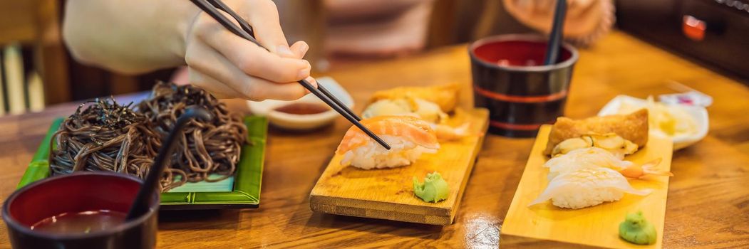 Young woman eating sushi in a cafe. BANNER, LONG FORMAT