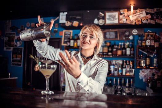 Girl bartender creates a cocktail at the beerhall