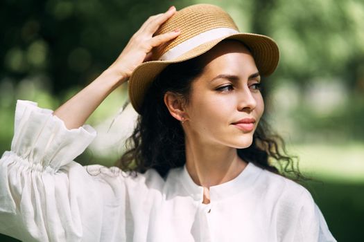 Young beautiful girl in a hat in a summer park. High quality photo