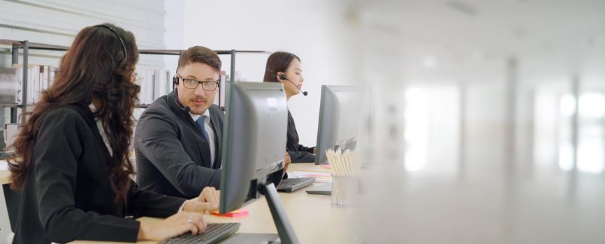 Business people wearing headset working in office to support remote customer or colleague. Call center, telemarketing, customer support agent provide service in broaden view .