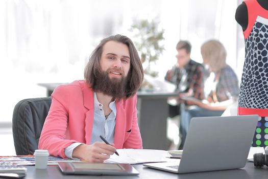 fashion designer uses a graphic tablet sitting at a Desk in the Studio.