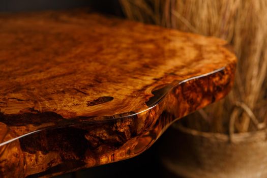 The edge of wooden stylish table made of solid walnut with epoxy resin in stylish interior