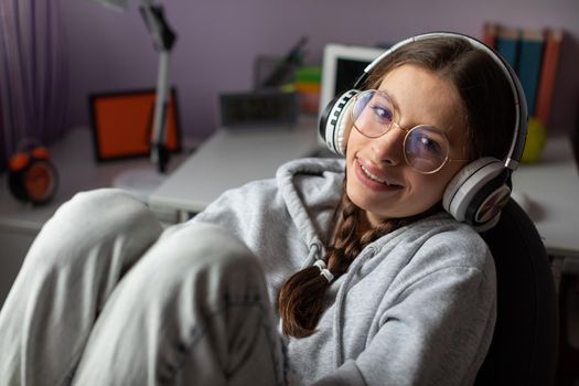Young brunette full of joy while listening to music on wireless headphones. Music emotion gives happiness and smile.