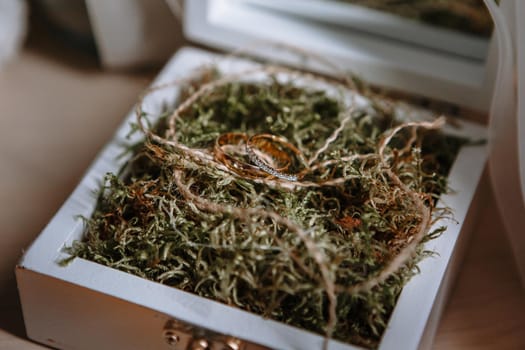 Gold wedding rings lying in a handmade white wooden box