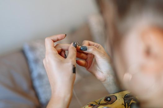 The seamstress's hands tuck the thread into the needle